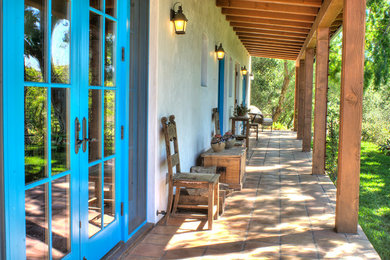 Mid-sized southwest tile side porch photo in Santa Barbara with a roof extension