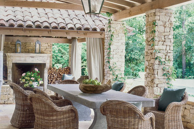 Inspiration for a large mediterranean stone back porch remodel in Houston with a pergola