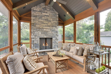 Inspiration for a large transitional back porch remodel in Minneapolis with a fire pit, decking and a roof extension
