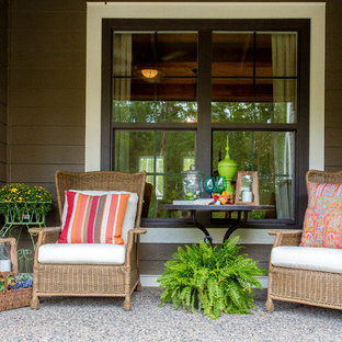 Immagine di un piccolo patio o portico american style davanti casa con un giardino in vaso, lastre di cemento e un tetto a sbalzo