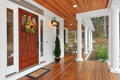 Cette photo montre un porche d'entrée de maison chic avec une terrasse en bois et une extension de toiture.