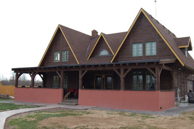 Photo of a large rustic front veranda in Toronto with brick paving and a roof extension.