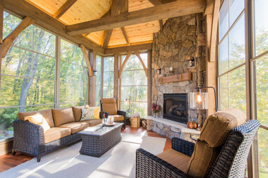 Large mountain style stone screened-in back porch photo in Minneapolis with a roof extension