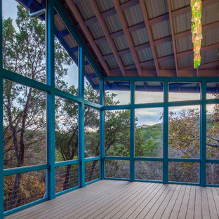 Mid-sized eclectic screened-in back porch idea in Austin with decking and a roof extension