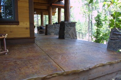 Huge mountain style stamped concrete back porch idea in Orlando with a roof extension