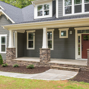 Esempio di un portico stile americano di medie dimensioni e davanti casa con lastre di cemento e un tetto a sbalzo