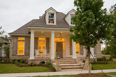Idee per un grande portico classico davanti casa con pavimentazioni in mattoni, un tetto a sbalzo e con illuminazione