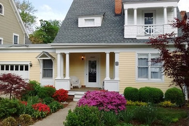 Mid-sized classic concrete front porch idea in DC Metro with a roof extension