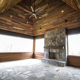 Idee per un portico country di medie dimensioni e dietro casa con un portico chiuso, pavimentazioni in pietra naturale e un tetto a sbalzo