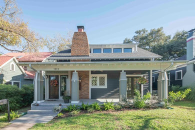 This is an example of a small traditional concrete front porch design in Austin with a roof extension.