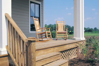 This is an example of a mid-sized farmhouse front porch design in Other with decking and a roof extension.