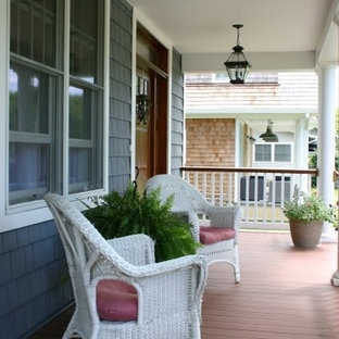 This is an example of a mid-sized traditional front porch design in New York with decking and a roof extension.