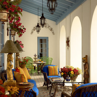 Esempio di un grande portico mediterraneo con piastrelle, un tetto a sbalzo e con illuminazione