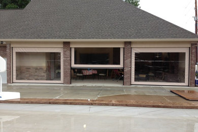 Inspiration for a large timeless concrete screened-in back porch remodel in Indianapolis with a roof extension