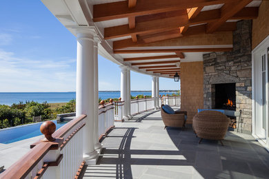 Mid-sized beach style back porch photo in Boston with a fire pit and a roof extension
