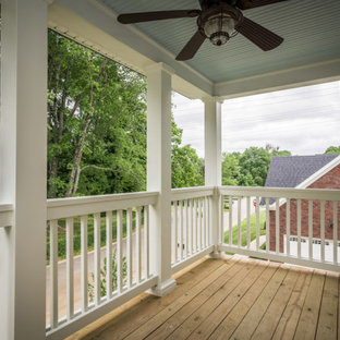 Immagine di un patio o portico con colonne chic davanti casa con un tetto a sbalzo
