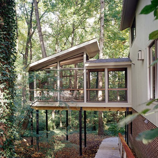 Immagine di un portico country con un tetto a sbalzo e un portico chiuso