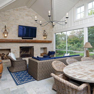 Inspiration for a large transitional stone back porch remodel in Wilmington with a fireplace and a roof extension