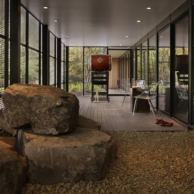 Mid-sized minimalist screened-in back porch idea in Seattle with decking and a roof extension