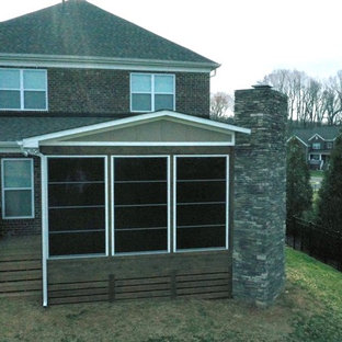 Foto di un portico american style dietro casa con un caminetto