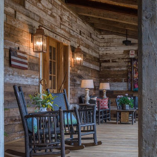 This is an example of a large farmhouse front porch design in Other with a roof extension.