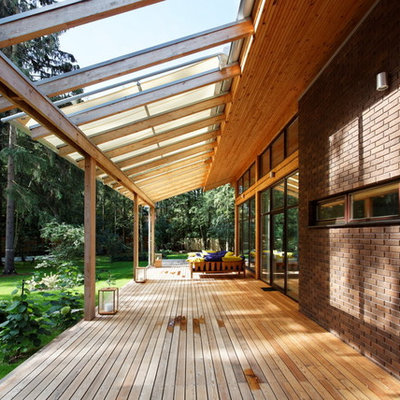 Trendy porch idea in Moscow with decking and a roof extension