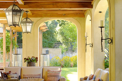 Diseño de terraza mediterránea grande en anexo de casas y patio trasero con adoquines de piedra natural y iluminación