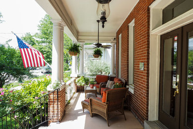 Mid-sized elegant concrete front porch photo in DC Metro with a roof extension