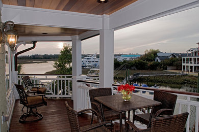 Large beach style front wood railing veranda in Wilmington with decking and a roof extension.