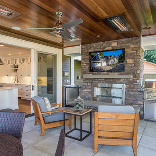 Foto di un portico american style dietro casa con un tetto a sbalzo e pavimentazioni in cemento