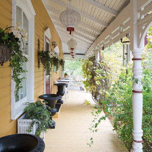 Ispirazione per un portico shabby-chic style davanti casa con pedane e un tetto a sbalzo