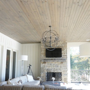Idee per un grande patio o portico american style dietro casa con un portico chiuso e un tetto a sbalzo