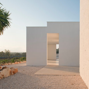 Immagine di un portico mediterraneo di medie dimensioni e davanti casa con un portico chiuso, pavimentazioni in cemento e un tetto a sbalzo