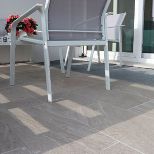 Ispirazione per un grande portico stile shabby davanti casa con piastrelle