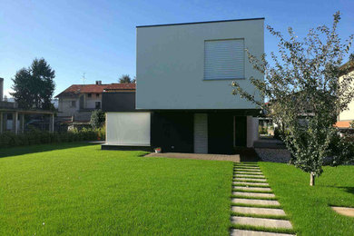 Imagen de terraza minimalista extra grande en patio delantero y anexo de casas con adoquines de piedra natural