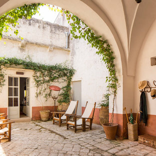 Esempio di un ampio portico mediterraneo davanti casa con un portico chiuso e pavimentazioni in pietra naturale