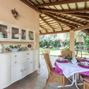 Idee per un patio o portico mediterraneo davanti casa con pavimentazioni in mattoni e un tetto a sbalzo