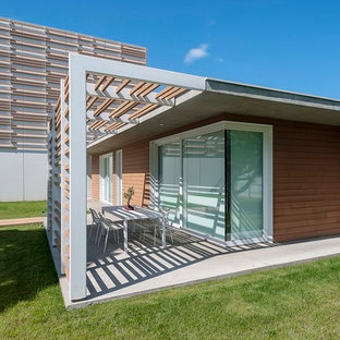 Idee per un piccolo patio o portico contemporaneo nel cortile laterale con una pergola e lastre di cemento