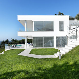 Foto di un grande portico minimal davanti casa con piastrelle e un tetto a sbalzo
