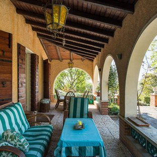 Idee per un grande portico country nel cortile laterale con un giardino in vaso, pavimentazioni in pietra naturale e un tetto a sbalzo