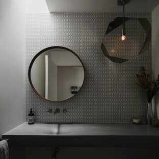 Inspiration pour un WC et toilettes vintage avec un carrelage gris, carrelage en mosaïque, un plan de toilette en béton et meuble-lavabo suspendu.