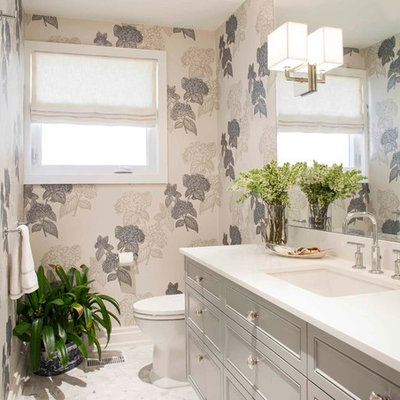 Mid-sized transitional marble floor and white floor powder room photo in Toronto with recessed-panel cabinets, gray cabinets, an undermount sink, quartz countertops, a one-piece toilet, white walls and white countertops