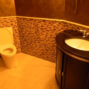 Esempio di un piccolo bagno di servizio contemporaneo con consolle stile comò, ante in legno bruno, WC monopezzo, piastrelle multicolore, piastrelle di vetro, pareti marroni, pavimento in pietra calcarea, lavabo sottopiano e pavimento beige