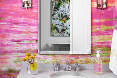 Modelo de aseo contemporáneo con paredes rosas, lavabo bajoencimera y encimeras grises