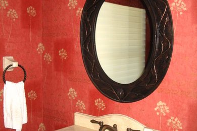 Ejemplo de aseo tradicional pequeño con lavabo integrado, armarios tipo mueble, encimera de mármol y paredes rojas