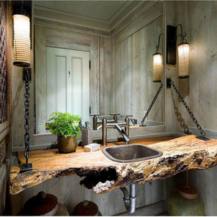Réalisation d'un WC et toilettes chalet avec un lavabo posé, un plan de toilette en bois et un plan de toilette marron.