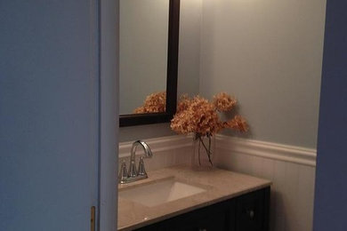 Example of a ceramic tile powder room design in Boston with granite countertops, a one-piece toilet and blue walls
