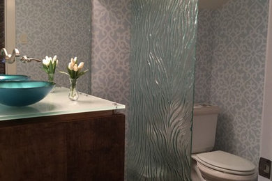 オースティンにある中くらいなトランジショナルスタイルのおしゃれなトイレ・洗面所 (分離型トイレ、マルチカラーの壁、濃色無垢フローリング、ベッセル式洗面器、ガラスの洗面台、茶色い床) の写真