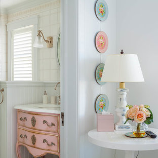 Idées déco pour un WC et toilettes romantique avec un lavabo encastré, un placard en trompe-l'oeil, des portes de placard rouges, un carrelage blanc et un mur blanc.