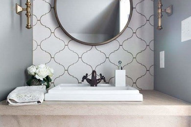 Small transitional white tile and cement tile brown floor powder room photo in Birmingham with a drop-in sink, limestone countertops and beige countertops